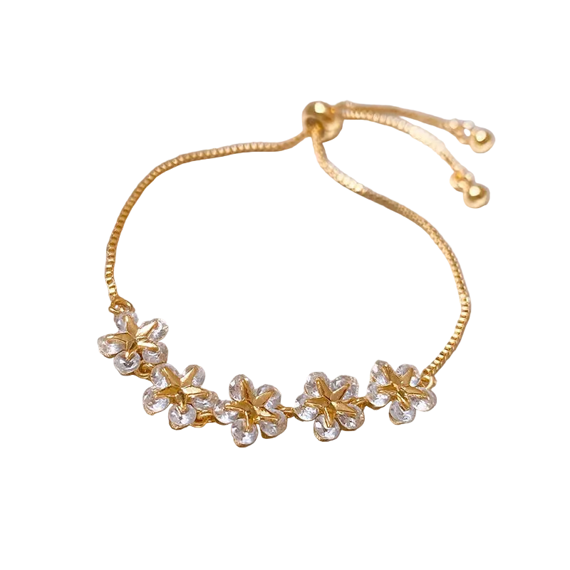 Gold bracelet with floral designs on a soft fabric background